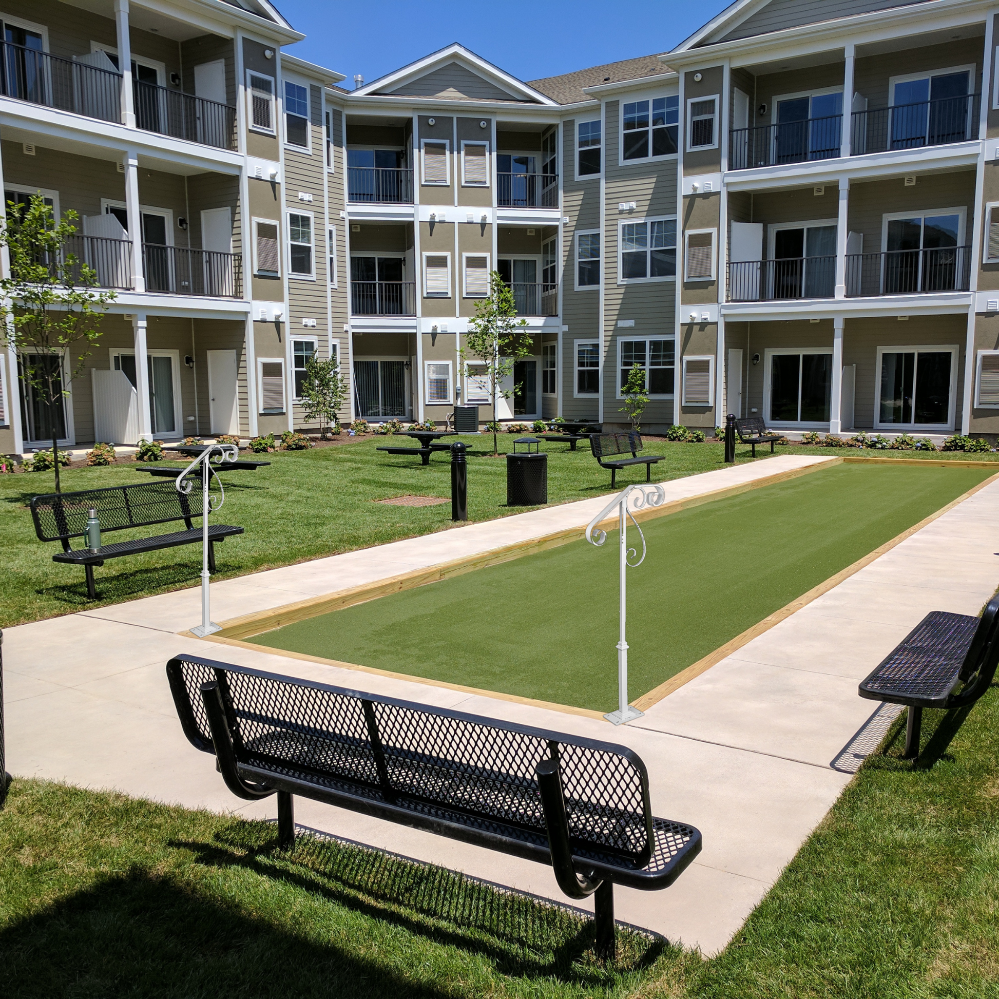 Decorative white safety handrails for bocce court